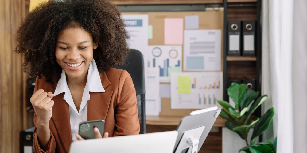 Travel professional using travel itinerary software on her smartphone at the office